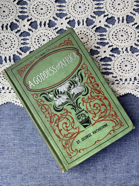 Vintage green hardcover book, A Goddess of Africa, with an ornate gold and red cover design